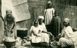 (Photographie einer Gruppe Frauen und Kindern beim Kochen) 