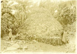 (Foto einer Frau und zweier Kinder vor einer Hütte) 