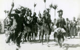 (Photographie einer Gruppe von Männern mit Speeren beim Aufführen eines Tanzes) 